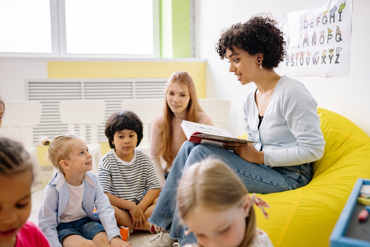 Kindergarten students children surrond teacher reading